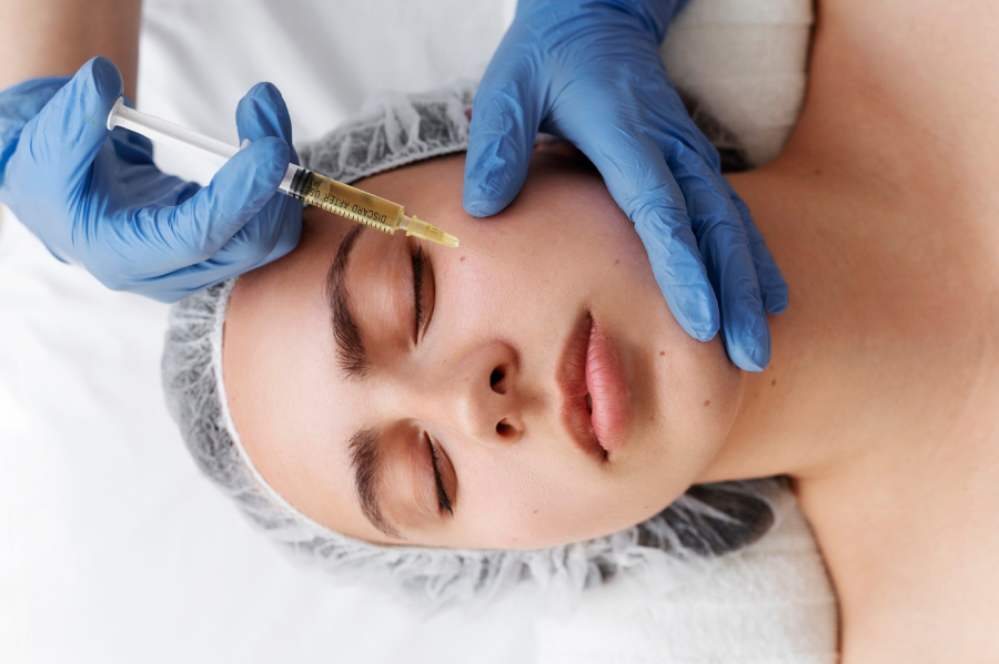 Close-up of woman receiving under-eye filler injection from aesthetician wearing blue gloves in beauty clinic.